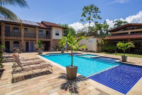 a swimming pool in front of a house at Pousada Eclipse Paraty in Paraty