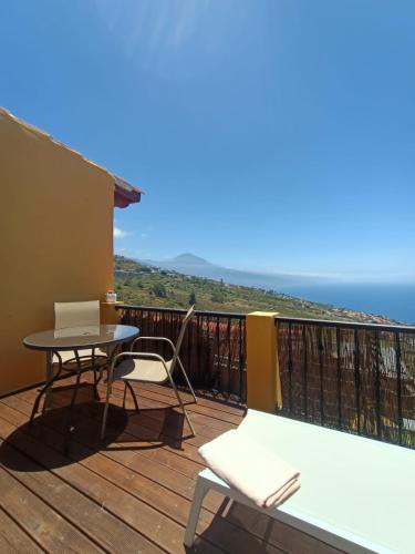 balcón con mesa, sillas y vistas al océano en Apartamento Mencey de StarApsTenerife, en Sauzal
