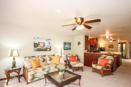 a living room with a couch and a ceiling fan at Waikomo Streams 202 in Kipu