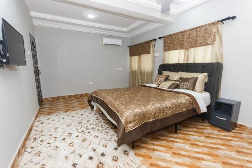 a bedroom with a large bed and a rug at Villadcoco in Nungua