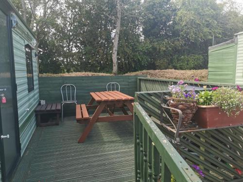 a wooden deck with a picnic table and chairs at Lochlands caravan park X(6) in Forfar