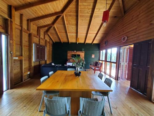 a dining room with a wooden table and chairs at Estancias Arroyazo in Constanza