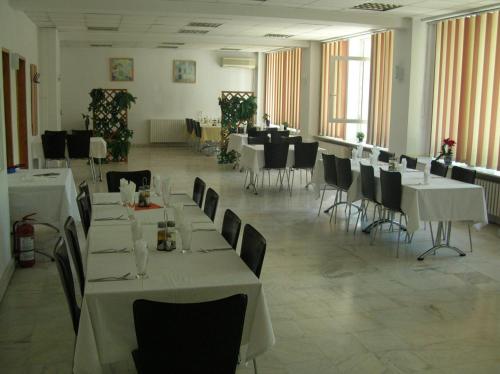 a dining room with white tables and chairs and tablesearcher at Federația Română de Scrimă - Hotel Floreta de Aur in Bucharest