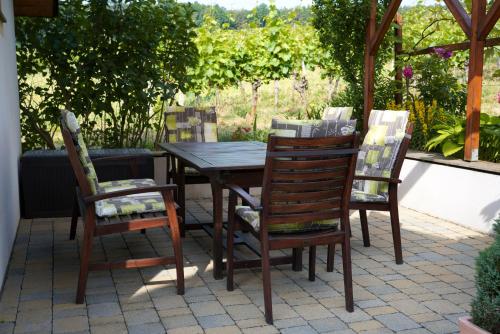 a wooden table and chairs on a patio at Kellerstöckl Weinberg in Eisenberg an der Pinka