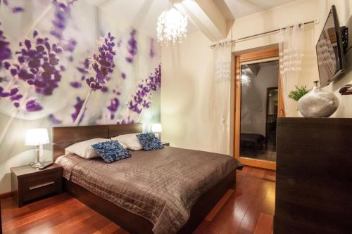 ザコパネにあるApartSerwis Gorące Źródła - Apartament Kozi Wierchのベッドルーム1室(紫色の花の壁にベッド1台付)