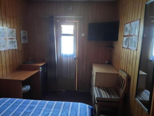 a room with a bed and a desk and a window at Victor-alojamientos in La Serena
