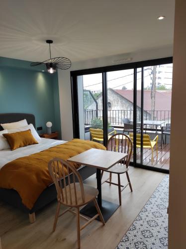 una camera con letto, tavolo e sedie di Appart hôtel & Spa La Villa du Port a Vannes