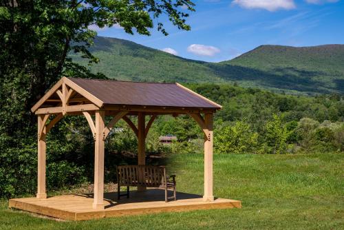 a wooden gazebo with a bench in a field at Aspen at Manchester in Manchester