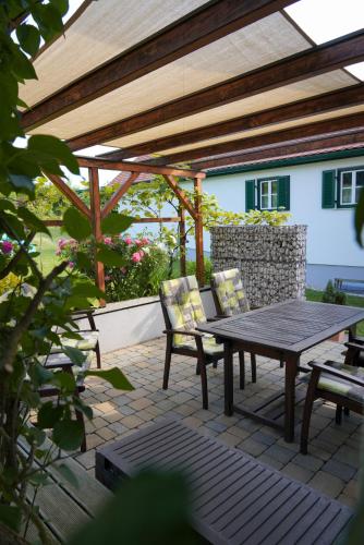 a wooden table and chairs on a patio at Kellerstöckl Weinberg in Eisenberg an der Pinka