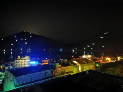 a city at night with a mountain in the background at lovely studio with awesome view in Tolo