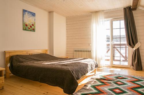 sypialnia z łóżkiem i dużym oknem w obiekcie Мигово Гражда w mieście Migowo