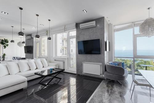 a living room with a white couch and a tv at Odesa Pearl Apartments in Odesa