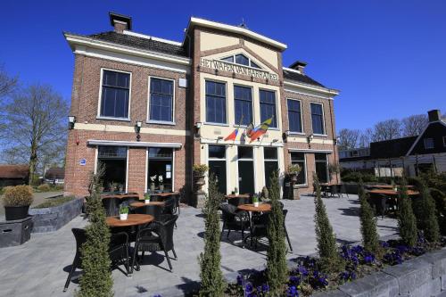 a restaurant with tables and chairs in front of a building at Jacuzzi & Sauna Villa 2 in Tzummarum