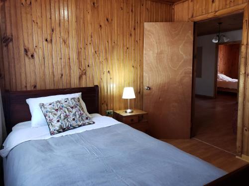 Dormitorio con cama con almohada y lámpara en Casa Aldunate, La calera, en La Calera