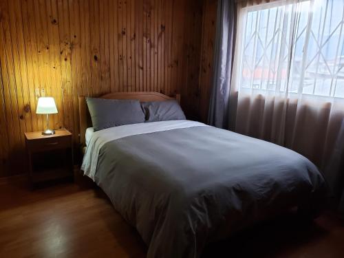 1 dormitorio con 1 cama grande y ventana en Casa Aldunate, La calera, en La Calera