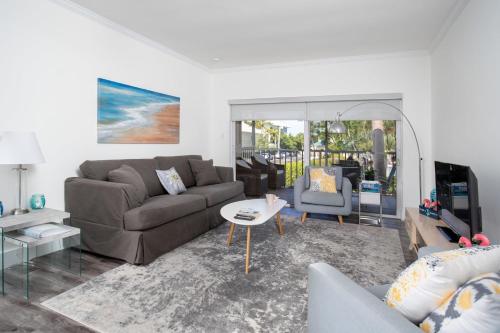 a living room with a couch and a table at Beach Living at Plantation Village BLGS in George Town
