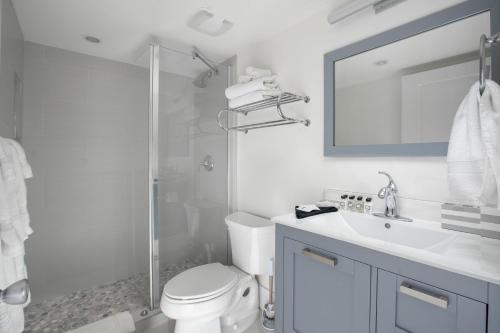 a bathroom with a toilet and a sink and a shower at Beach Living at Plantation Village BLGS in George Town