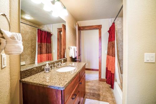 uma casa de banho com um lavatório e um espelho grande em Cornerstone Town Home 49 em Steamboat Springs