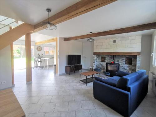 a living room with a blue couch and a fireplace at The stopover in Bonneuil in Bonneuil-les-Eaux