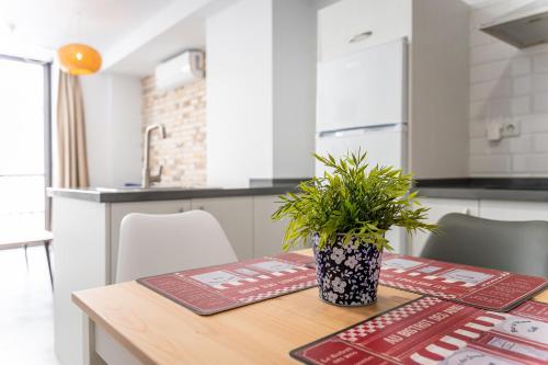 uma cozinha com uma mesa com um vaso de plantas em LA TRINIDAD SUITES em Fuengirola