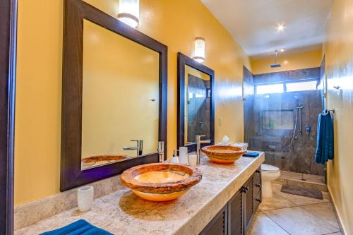2 lavabos en un baño con 2 espejos en Hacienda Style Apt with Oceanview Roof Pool & Cenote!, en Playa del Carmen