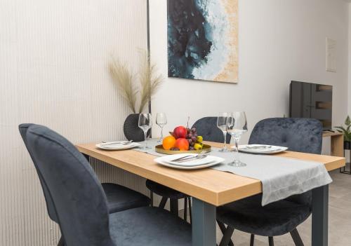 a dining room table with chairs and a bowl of fruit at Apartments Niko in Makarska