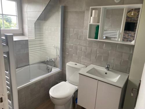 een badkamer met een toilet, een wastafel en een bad bij Appartement cosy et neuf au pied des commerces in Pléneuf-Val-André