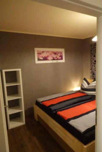 a bedroom with a bed and a book shelf at Ferienwohnung zum See in Görlitz