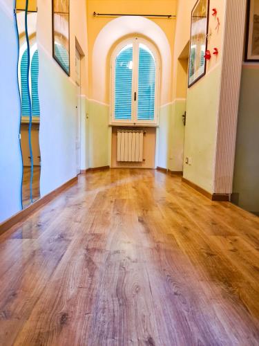 an empty room with wood floors and a window at Villa Zara in Siena