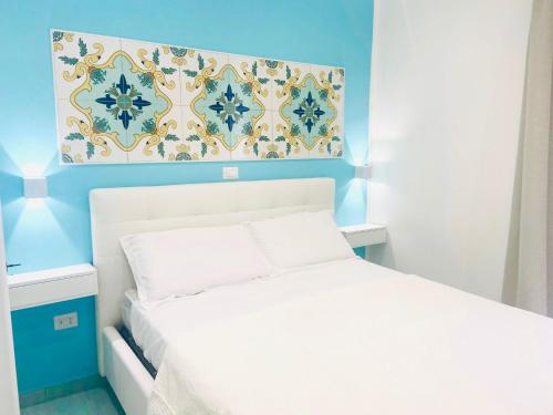 a bedroom with a white bed and a blue wall at Cilento Experience rooms in Marina di Camerota