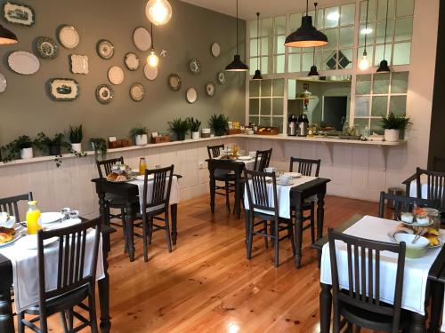 a restaurant with tables and chairs in a room at Porto Vintage Guesthouse in Porto