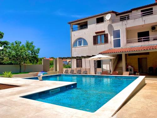 una piscina frente a una casa en Linc Rooms & Apartments, en Banjole