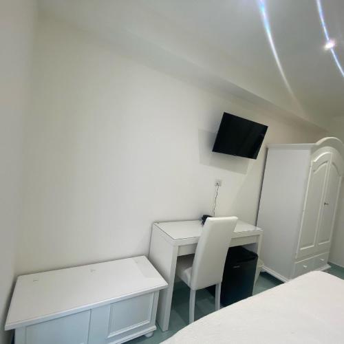 a white room with a desk and a white chair at Cilento Experience rooms in Marina di Camerota
