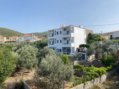 a white apartment building in the middle of trees at Studio Mare in Megalochori