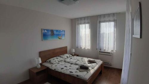 a white bedroom with a bed and a window at Apartment in Balatonalmadi 36663 in Balatonalmádi
