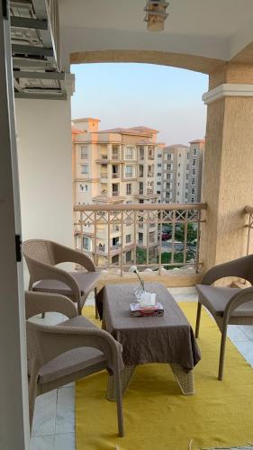 a patio with a table and chairs on a balcony at Executive 2 BedRoom Hotel Apmt Contactless check-in Premium Services and Quality at Madinaty in Madīnat ash Shurūq