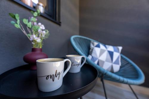 two cups of coffee on a table with a vase at Apartman CROWN Zlatibor Vila Leonardo 6 in Zlatibor