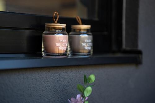 two jars are sitting on a shelf at Apartman CROWN Zlatibor Vila Leonardo 6 in Zlatibor