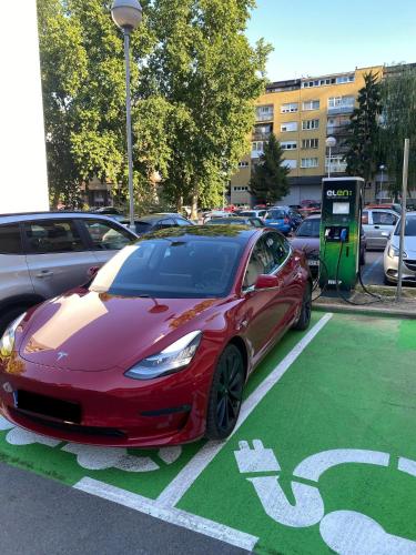 a red car is parked in a parking lot at Apartman ZITA in Osijek