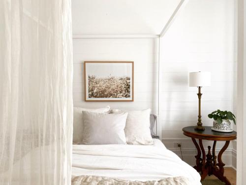 Dormitorio blanco con cama y mesa en Castlebar - Superior Boutique Accomodation - Steps to Pakington Street, en Geelong West