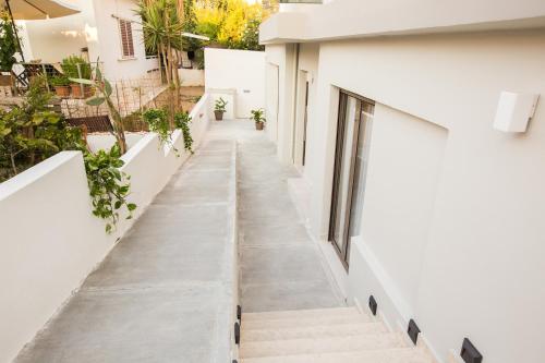 a hallway of a white building with stairs at Calmare suites in Rethymno Town