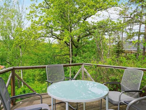 2 person holiday home in HANINGE في هانينيه: طاولة وكراسي على سطح مع أشجار
