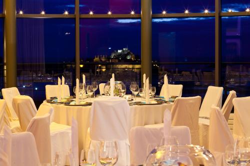 a dining room with white tables and white chairs at Radisson Blu Waterfront Hotel, Jersey in Saint Helier Jersey