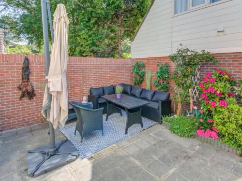 a patio with a table and an umbrella at Comfortable vacation home near the sea in Noordwijkerhout