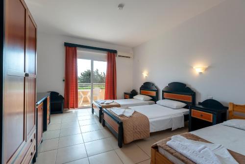 a hotel room with two beds and a window at Cirillo Family Hotel-Christinas Studios in Mastichari