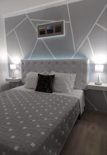 a bedroom with a large bed with two lamps at Casa Da Praia "AL" in Monte Gordo