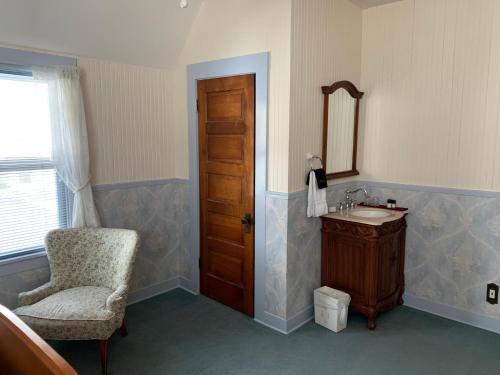 a bathroom with a chair and a sink and a mirror at Mount Shasta Ranch Bed and Breakfast in Mount Shasta