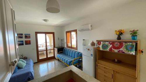 レトイアンニにあるCasa Morgantinaのリビングルーム(青いソファ付)、キッチン