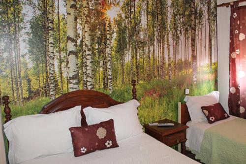a bedroom with a bed and a mural of trees at Pensão França in Porto