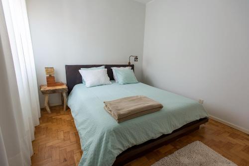 een slaapkamer met een bed met een kussen erop bij Casa do Remo Praia da Aguda in Arcozelo
